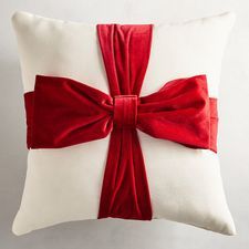 a white pillow with a red bow on it