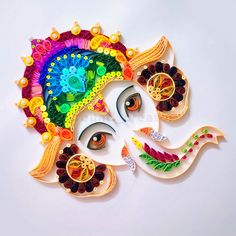 an intricately designed ganeshi with colorful decorations on it's face and eyes