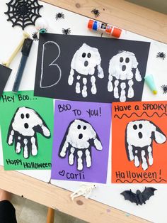 four handprinted halloween cards on a table with markers and crayon pens