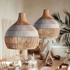 two wooden lamps hanging from the ceiling above a table