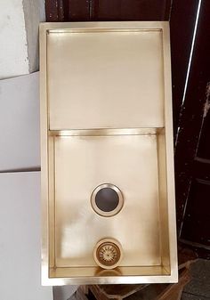 a gold sink sitting on top of a white tile floor next to a brown door