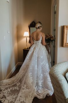 a woman in a wedding dress looking at herself in the mirror