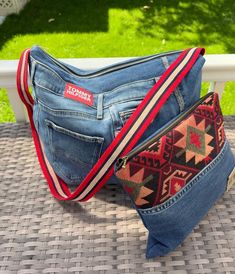 two denim purses sitting next to each other on top of a table with grass in the background