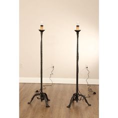 two black metal floor lamps on wooden floors