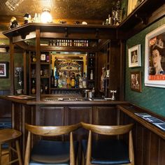 a bar with wooden chairs and pictures on the wall