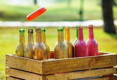 a wooden crate filled with bottles and a frisbee