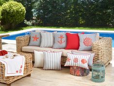 a wicker couch sitting on top of a wooden floor next to a swimming pool