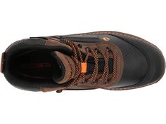 the shoe is brown and black with orange laces on it's outstep