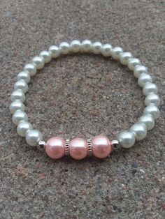 This elegant bracelet is made with white, pink, and silver beads, silver cogwheel spacers, and stretch cord. These would make lovely accessories to weddings, Easter celebrations, or any other special occasion! They also make beautiful gifts! If ordering for a child, please put so in the note section when checking out and the age of the child (bracelets shown in pictures are adult sizes). *If your wrist runs small, either message me or put something in the comment section of your purchase order to make it a little smaller* *Remember to roll stretch bracelets over the hand to preserve shape and elasticity and reduce stretching out to much* *The goal of my shop is to make available elegant, beautiful jewelry that anyone can afford so all items are $15 and under! If you see an item you like bu White Pearl Bracelet With Spacer Beads For Wedding, White Beaded Bracelets With Spacer Beads For Wedding, White 8mm Beads Bracelets For Wedding, White 8mm Beaded Bracelets For Wedding, White 8mm Beads Bracelet For Wedding, Adjustable White Charm Bracelet With Silver Beads, White Beaded Bracelet, White Beads Bracelet, Diy Bracelets Tutorials