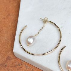 14KT yellow gold c-shape hoop earrings with white freshwater pearl charms dangling from chain. Length: 40mm Width: 1.5mm hoop Weight: 3.50 grams Freshwater pearls 10 x 8mm freshwater pearls Modern Small Hoop Jewelry With Pearl Drop, Modern Small Hoop Pearl Drop Jewelry, Modern Hoop Jewelry With Pearl Charm, Elegant Dangle Hoop Earrings With Cable Chain, Modern Dangle Pearl Chain Jewelry, Gold Plated Hoop Pearl Chain Jewelry, Modern Hoop Pearl Jewelry, Modern Pearl Hoop Jewelry, Yellow Gold Hoop Earrings With Pearl Pendant