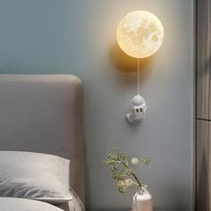 a bedroom with a bed, night light and vase on the nightstand next to it