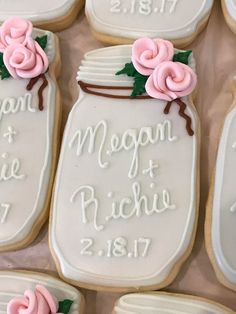 decorated cookies in the shape of mason jars with pink flowers on them for a wedding