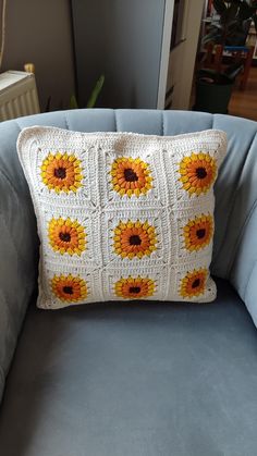 a crocheted sunflower pillow on a blue couch