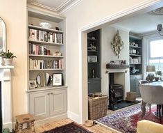 a living room filled with furniture and a fire place next to a book shelf full of books