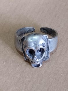 I SHIPPING WITH INTERNATIONAL PRIORITY MAIL. SMALL CAST METAL RING  REGOLABILE VINTAGE 80S  DEADSTOCK.  TENEBROSO, OSCURO ANELLO.  DIAMETRO MINIMO 2 CM.  Skull, cast metal ring vintage 80S, gothic horrible skull, oscuro e tenebroso teschio.  anello della morte. per veri amanti delle tenebre Collectible Symbolic Skull Ring For Halloween, Collectible Skull Rings For Halloween, Vintage Skull Print Rings As Gift, Handmade Vintage Rings For Halloween, Collectible Skull Ring For Halloween, Vintage Metal Rings For Halloween, Gothic Skull Print Rings For Halloween, Vintage Hand Cast Skull Ring As Gift, Adjustable Vintage Skull Ring For Halloween