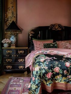 a bedroom with pink walls and black furniture