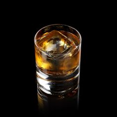 a glass filled with ice sitting on top of a table