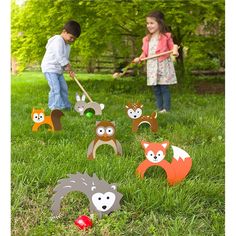 two children playing in the grass with paper animals