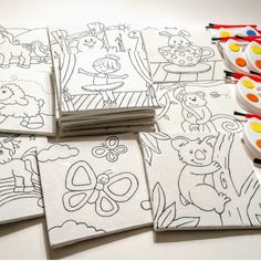 many coloring pages are stacked on top of each other with markers in front of them