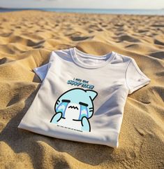 A cute and funny tee featuring a crying shark and a humorous phrase. This tee gives off a light-hearted and playful vibe, perfect for casual wear or lounging around. Ideal for those who enjoy quirky and unique designs, this tee is great for shark lovers or anyone looking to add some fun to their wardrobe. Perfect for gifting on birthdays, Shark Week, or just to bring a smile to someone's face. Product features - Shoulder tape for stability - Ribbed knit collar for elasticity - Smooth fabric perfect for printing - Made with sustainable 100% cotton - Classic fit for comfy wear Care instructions - Machine wash: warm (max 40C or 105F) - Non-chlorine: bleach as needed - Tumble dry: medium - Do not iron - Do not dryclean Funny Shark, Shark Tee, Sharks Funny, Shark Lover, Comfy Wear, Shark T Shirt, Shark Week, Ocean Lover, Animal Shirts