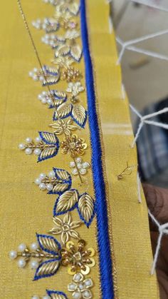 a close up of a table cloth with gold and blue trimmings on it