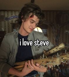 a man holding a large piece of wood with the words i love steve on it