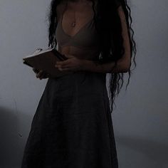 a woman with long hair is holding a book