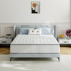 a white bed sitting on top of a wooden floor