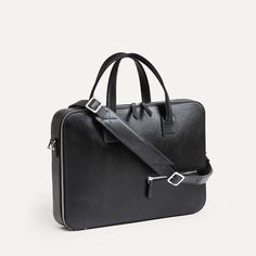 Ce briefcase Paolo propose un design très épuré. Aucune poche extérieure ne vient perturber le volume du sac en dehors de notre poche signature sur l’avant : une poche zippée permettant de venir y glisser son passeport. Un sac très compact qui vous surprendra par ses capacités de rangement ! Côté matière, ce sac est réalisé dans notre cuir Saffiano, un cuir pleine fleur de grande qualité, à l’aspect légèrement satiné et qui ne s’altèrera pas avec le temps. Les fermetures à glissières sont réalisées par YKK, un des plus grand spécialistes au monde, et nos mousquetons réalisés en laiton pour garantir une résistance maximale. Le porte-documents Paolo est proposé avec sa sangle en cuir pour un porté épaule, et vous sera livré dans un pochon de protection. Sleek Leather Briefcase For Formal Occasions, Modern Top Handle Briefcase, Sleek Rectangular Briefcase For Formal Use, Modern Epsom Leather Satchel, Sleek Rectangular Briefcase For Formal Occasions, Black Saffiano Leather Briefcase For Work, Designer Saffiano Leather Briefcase For Formal Use, Black Saffiano Leather Shoulder Bag For Business, Designer Formal Shoulder Bag With Luggage Sleeve