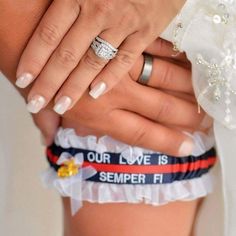 two hands holding each other with wedding rings on their fingers and the words our love is semper f written on them