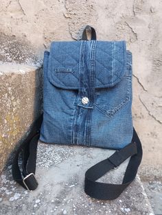 This recycled denim backpack will be your favorite adventure companion. Medium in size but still fits a lot of things. It is light, comfortable and resistant! The button on the jeans is the one that closes the flap. This denim backpack is handmade from recycled jeans, the most characteristic part of which is the front and back pockets. The jean's belt acts as a closure. The interior is spacious and also has two small pockets and one larger zippered pocket. Long, adjustable cotton straps and the top handle is leather. Unique and original denim backpack, and every detail has been taken care of in its preparation to obtain a sustainable and quality item. Measures. 26 cm high x 25 cm wide x 8 cm deep. Long, adjustable straps. Details. . Recycled jeans . cotton lining . Handmade . cotton straps Handmade Backpack, Handmade Backpacks, Flap Backpack, Recycled Jeans, Jean Belts, Conscious Fashion