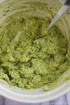 a white bowl filled with guacamole on top of a table