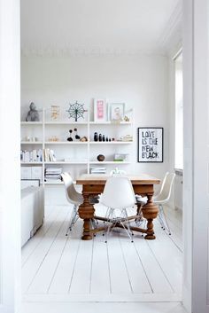 a dining room with white walls and wooden table