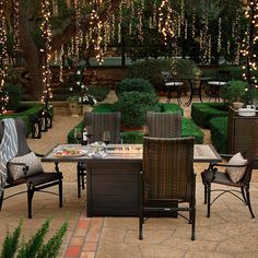 an outdoor dining area with lights strung from the trees