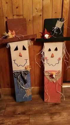 two scarecrows made out of paper bags sitting next to each other on the floor