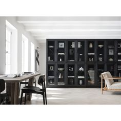 a living room filled with furniture and lots of shelves next to a dining room table