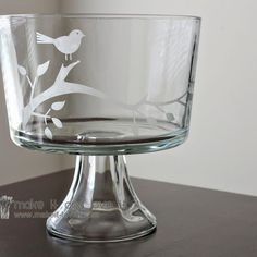 an empty glass bowl sitting on top of a table