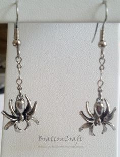 I love these hanging spider earrings! The charm is made of lead free pewter in the USA with an antique silver finish. The chain is rhodium finished base metal and the earwire is stainless steel. The length of this earring is 1-3/16 from the end of the earwire. Plastic earring backs are included. These earrings are ready to ship an will arrive in a gift box. I can shorten or lengthen these earrings by removing or adding chain. Contact me if you want me to make something special for you. Check out Halloween Dangle Metal Earrings, Halloween Themed Silver Earrings, Hanging Spider, Spider Earring, Spider Jewelry Vintage, Silver Spider Necklace, Spider Jewelry, Spider Earrings, Jewelry Halloween