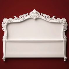 an ornate white bed frame against a red wall with the headboard made out of wood