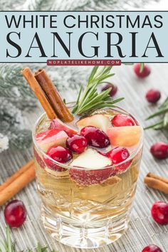 white christmas sangria in a glass with cinnamon sticks and cranberries on the side