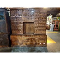 a large wooden cabinet with many drawers and doors on it's sides in a store