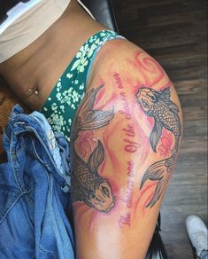 there is a woman with a tattoo on her arm that has koi fish in it