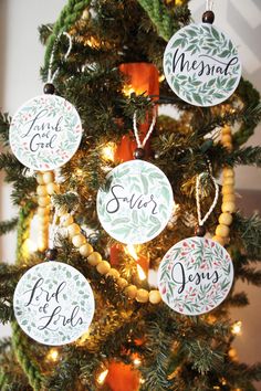 a christmas tree decorated with ornaments that say merry and the names of each family on it