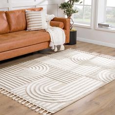 a living room with a brown couch and white rug