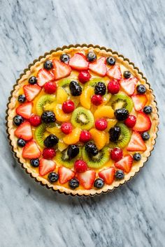 a fruit tart with kiwis, strawberries and oranges in it