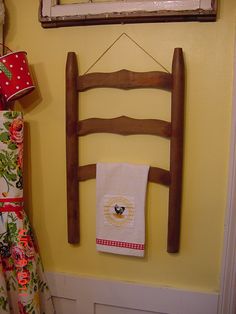 a wooden chair hanging on the wall next to a towel rack