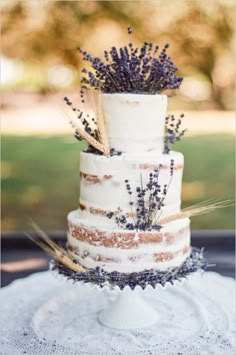 a three tiered cake with lavender sprigs on top