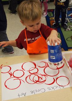 a young boy is pouring something into a can