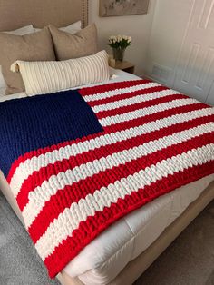 a large american flag blanket on top of a bed in a room with carpeting