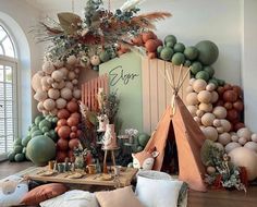 a room filled with lots of different types of balloons and decorations on the wall, including a teepee tent